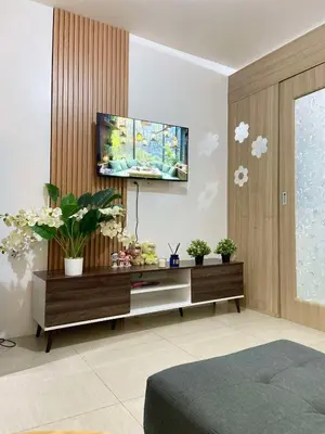 a living room with a tv on a wall at Leisure Suite Staycation in Manila