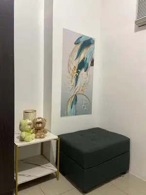a bedroom with a black ottoman and a table with stuffed animals at Leisure Suite Staycation in Manila