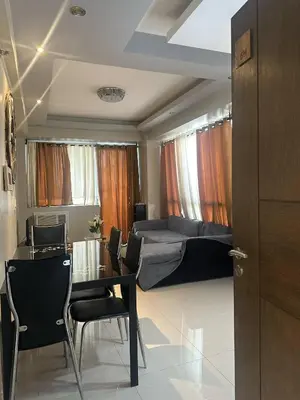 a bedroom with a bed and a table and chairs at Shore 2 Residence Staycation 1 in Manila