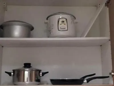 a pot and pans on a shelf above a stove at Shore 2 Residence Staycation 1 in Manila