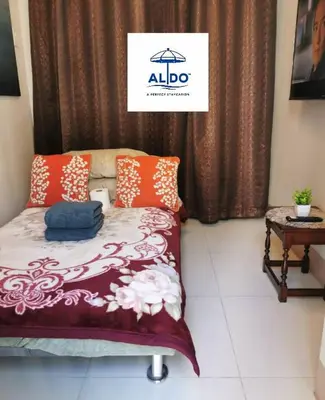 a bedroom with a bed with an alllde sign on it at Mall of Asia condotel in Manila