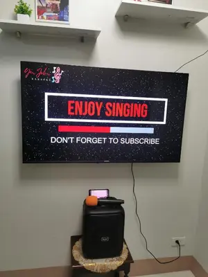 a sign on a wall that says enjoy singing dont forget to subscribe at Mall of Asia condotel in Manila