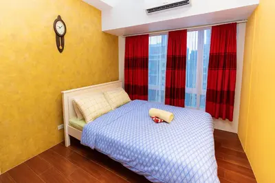 a small bedroom with a bed and a clock on the wall at SkyVista Luxe Makati Staycation Pool Gym Netflix 5637 in Manila