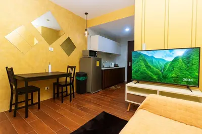 a living room with a television and a dining room table at SkyVista Luxe Makati Staycation Pool Gym Netflix 5637 in Manila
