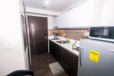 a small kitchen with a refrigerator and a microwave at The Giggle Spot Cozy Makati Hideaway Pool & Gym 2270 in Manila