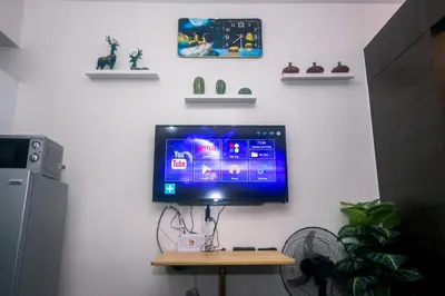 a flat screen tv hanging on a wall at The Giggle Spot Cozy Makati Hideaway Pool & Gym 2270 in Manila