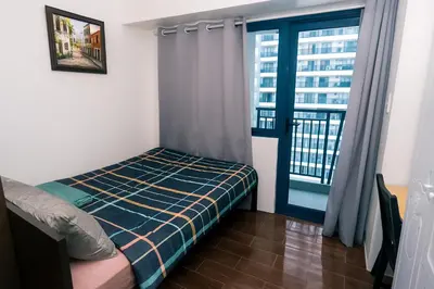 a bedroom with a bed and a window with a view at Makati MoodPad Fun Cozy Pool Access 300Mbps WiFi 2271 in Manila