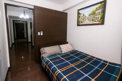 a bedroom with a bed and a picture on the wall at Makati MoodPad Fun Cozy Pool Access 300Mbps WiFi 2271 in Manila