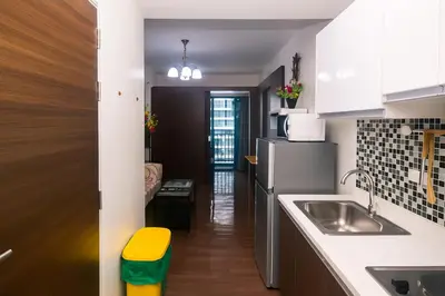 a small kitchen with a sink and a refrigerator at Makati MoodPad Fun Cozy Pool Access 300Mbps WiFi 2271 in Manila