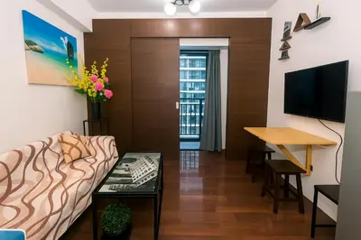 a living room with a couch and a table at Makati MoodPad Fun Cozy Pool Access 300Mbps WiFi 2271 in Manila