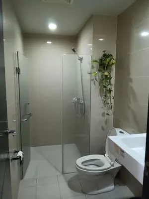 a bathroom with a shower and a toilet and a sink at M&N Condotel in Manila