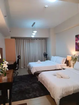 a hotel room with two beds and a desk at M&N Condotel in Manila