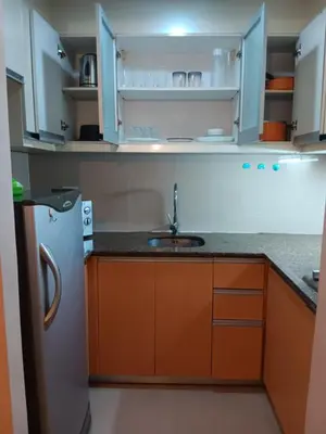 a small kitchen with a sink and cabinets at M&N Condotel in Manila