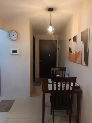 a dining room with a table and chairs and a clock at M&N Condotel in Manila