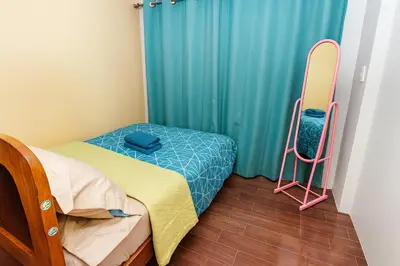 a small bedroom with a bed and a surfboard at Sunlit Makati Haven Cozy 1BR Gym Pool 1703 in Manila