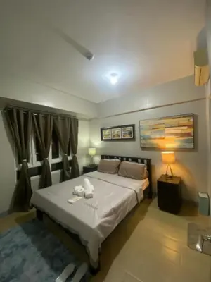 a bedroom with a bed with two towels on it at M&N Condotel in Manila