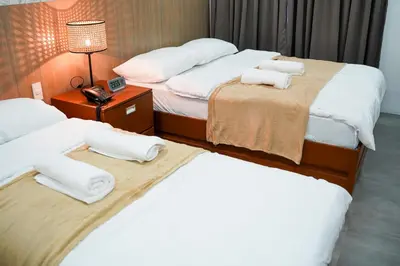 a hotel room with two beds and a lamp at Gimaca Boutique Hotel in Manila