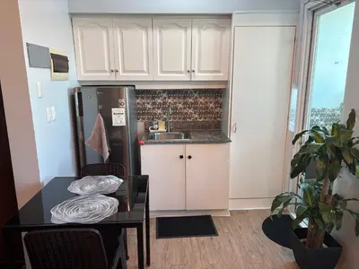 a small kitchen with a table and a refrigerator at Peaceful Getaway in Manila