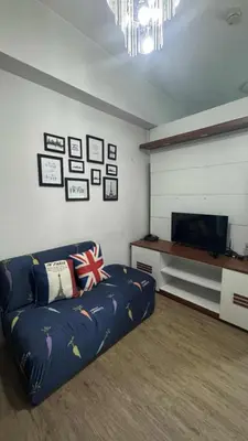 a living room with a couch and a flat screen tv at Peaceful Getaway in Manila