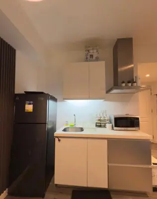 a kitchen with a black refrigerator and a sink at Azure Residences Getaway in Manila