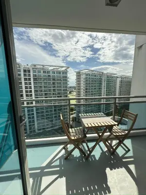 a table and chairs on a balcony with a view of buildings at Azure Residences Getaway in Manila