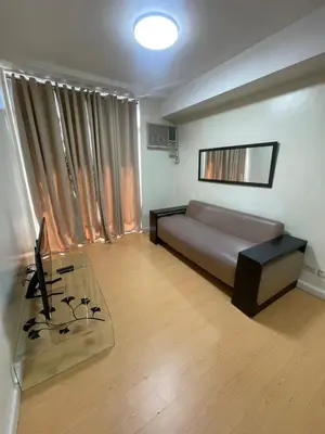a living room with a couch and a glass table at A Venue Residences 2403 in Makati