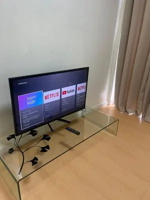 a flat screen tv sitting on top of a glass table at A Venue Residences 2403 in Makati