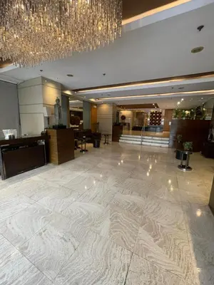 a lobby with a large marble floor and a chandelier at A Venue Residences 2403 in Makati