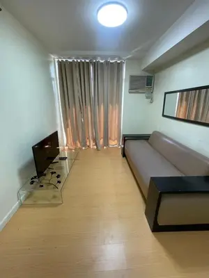 a living room with a couch and a table at A Venue Residences 2403 in Makati