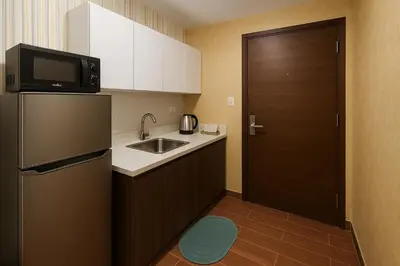 a small kitchen with a sink and a refrigerator at Serene Stay Air Makati Boutique Comfort City Perks 1767 in Manila