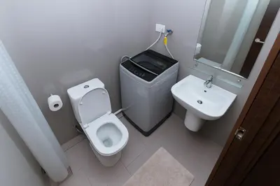 a small bathroom with a toilet and a sink at Serene Stay Air Makati Boutique Comfort City Perks 1767 in Manila