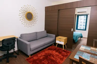 a living room with a couch and a table at The Plush Pad Makati Ayala Views 300MB WiFi 1940 in Manila