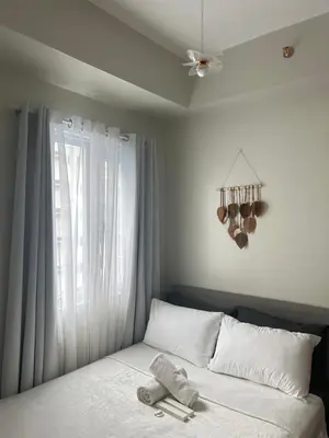 a bedroom with a bed with a window and a fan at The Minimal Getaway in Manila