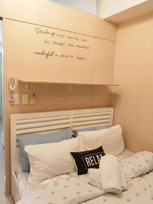 a bedroom with a bed with a writing on the wall at Maria's staycation in Manila