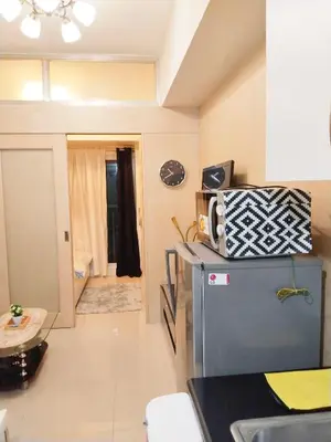 a kitchen with a sink and a refrigerator with a microwave at Maria's staycation in Manila