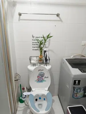 a small bathroom with a toilet with a toilet seat at Maria's staycation in Manila