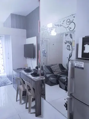 a kitchen and living room with a table and a refrigerator at Maria's staycation in Manila