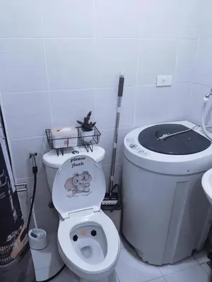 a bathroom with a toilet with a monkey sticker on it at Maria's staycation in Manila