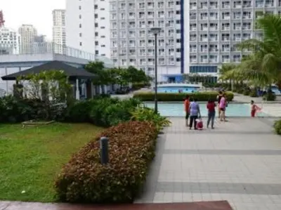 a group of people walking down a sidewalk in a city at Maria's staycation in Manila