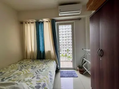 a bedroom with a bed and a large window at Apartments at Shore 1 Residences MOA Pasay Near Airport in Manila