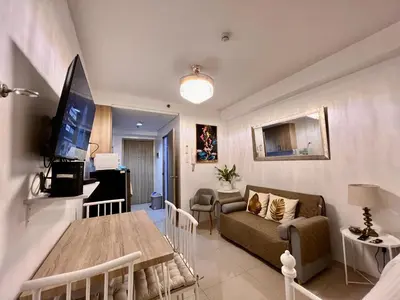 a living room with a couch and a table at Apartments at Shore 1 Residences MOA Pasay Near Airport in Manila