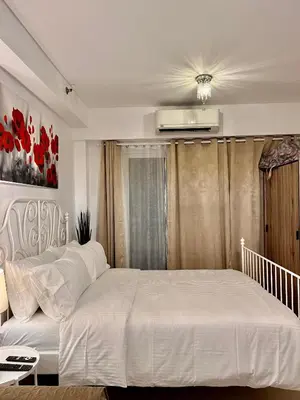 a bedroom with a large bed with a white bedspread at Apartments at Shore 1 Residences MOA Pasay Near Airport in Manila
