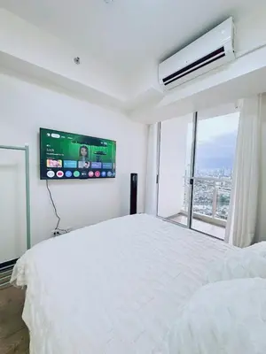 a bedroom with a white bed and a flat screen tv at Skyline Hideout in Sampong
