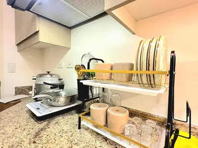 a kitchen with a counter with dishes on a shelf at Skyline Hideout in Sampong