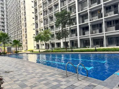 a swimming pool in front of a large building at Cozy Condo Near MOA & Airport in Manila