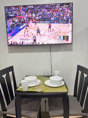 a table with two chairs and a tv on a wall at Cozy Condo Near MOA & Airport in Manila