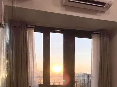 a room with a window with a view of the sunset at Awsome Corner Unit at Shore 3 in Manila