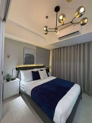 a bedroom with a large bed and a chandelier at Azure Residences Penthouse in Manila