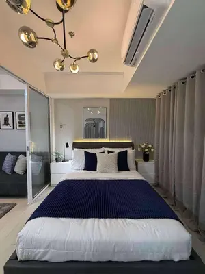 a bedroom with a large bed and a chandelier at Azure Residences Penthouse in Manila