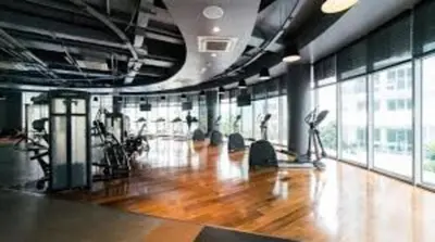 a gym with a wooden floor and large windows at Azure Residences Penthouse in Manila